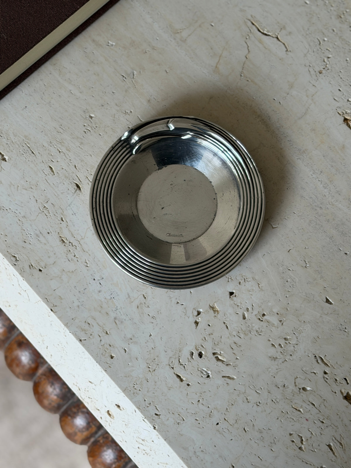 Overhead view of the Christofle ribbed dish, seven raised rings circling a plain center with the Christofle script mark