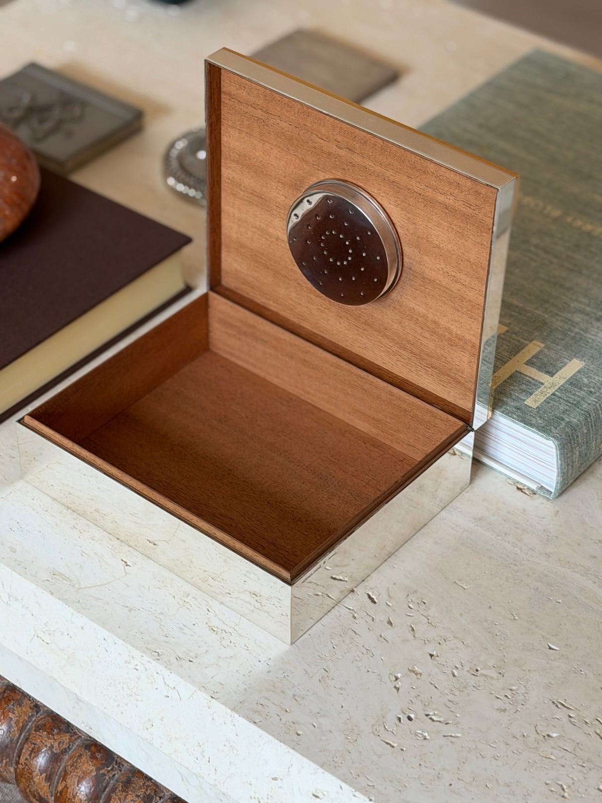 Open Hermes humidor showing the wood-lined interior and its perforated humidifier disc