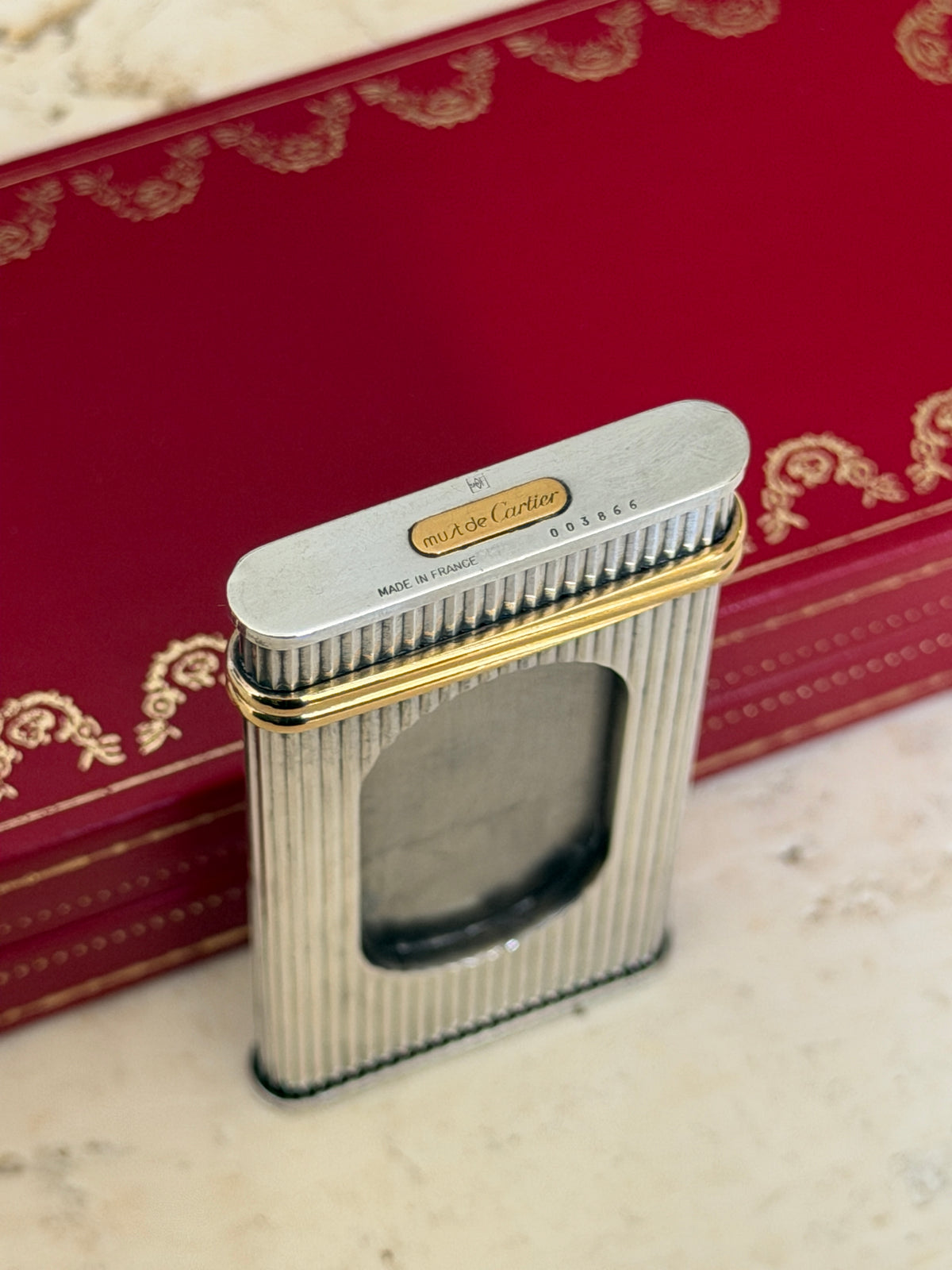 Close up of the cigar cutter end showing the gold must de Cartier plaque, serial number 003866, and Made in France stamp