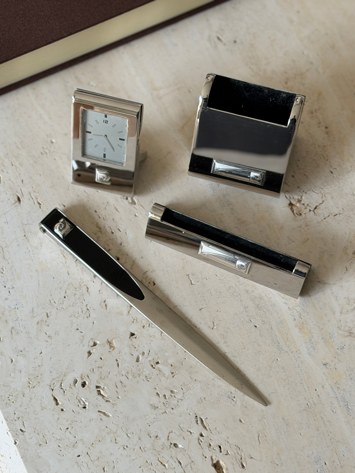Close overhead view of the Pierre Cardin pieces, showing the black lined pen tray, spiral logo plaques, and long pointed letter opener blade