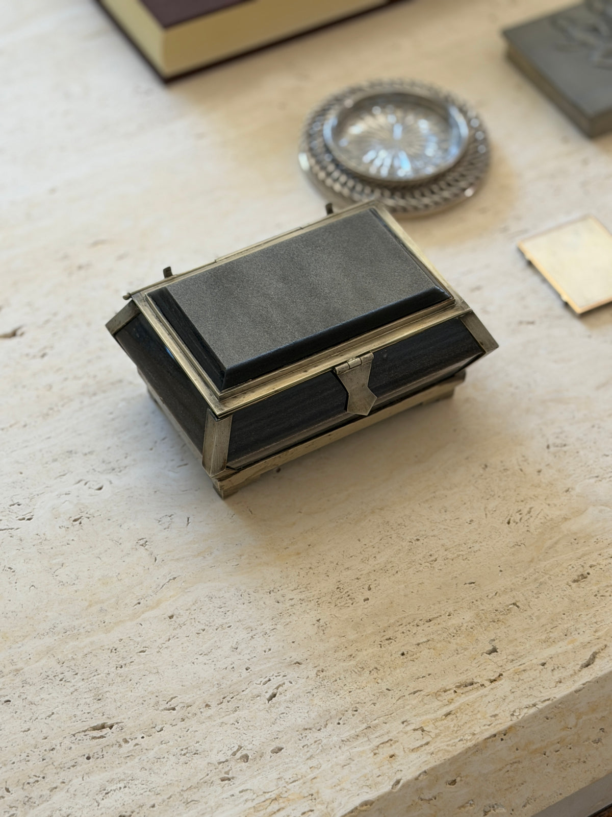 Overhead view of the black stone box showing the raised beveled stone lid framed in silver tone metal and the pointed hasp at the front