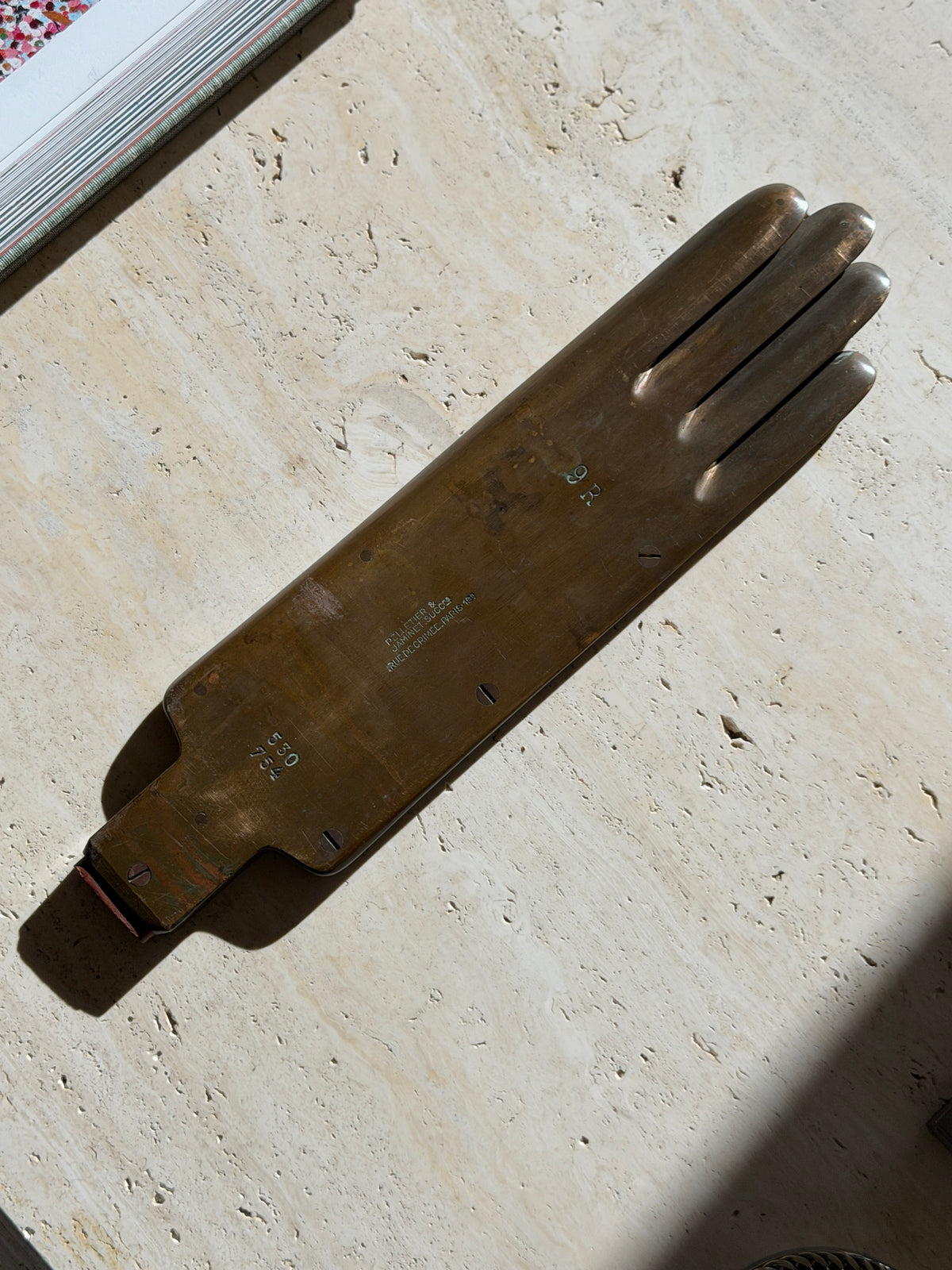 Overhead view of the flat brass glove form stamped 9R and 530 754, the Pelletier and Jaminet Paris maker&