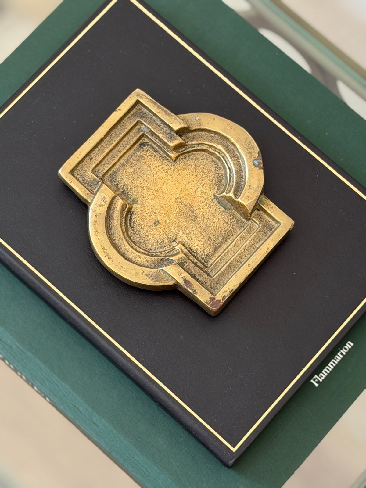Close-up top-down view of aged bronze architectural geometric tray showing muted gold patina details