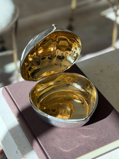 Cartier chestnut box opened on a brown book, revealing a fully gilt interior in both the lid and the base
