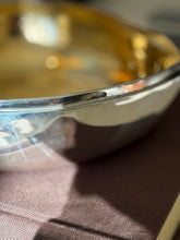 Close up of the CARTIER stamp on the outer rim of the sterling silver chestnut box, the gilt interior glowing behind