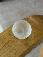 Close-up view highlighting etched Cartier signature on underside of frosted crystal golf ball paperweight