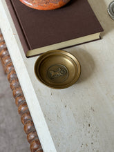 Another angle of the dish on the stone table beside the book and an orange stone bowl