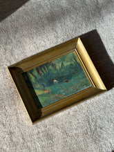 Overhead view of the small framed French landscape on a boucle rug, signed C. Morand at lower right, a figure crouching at the dark pond edge