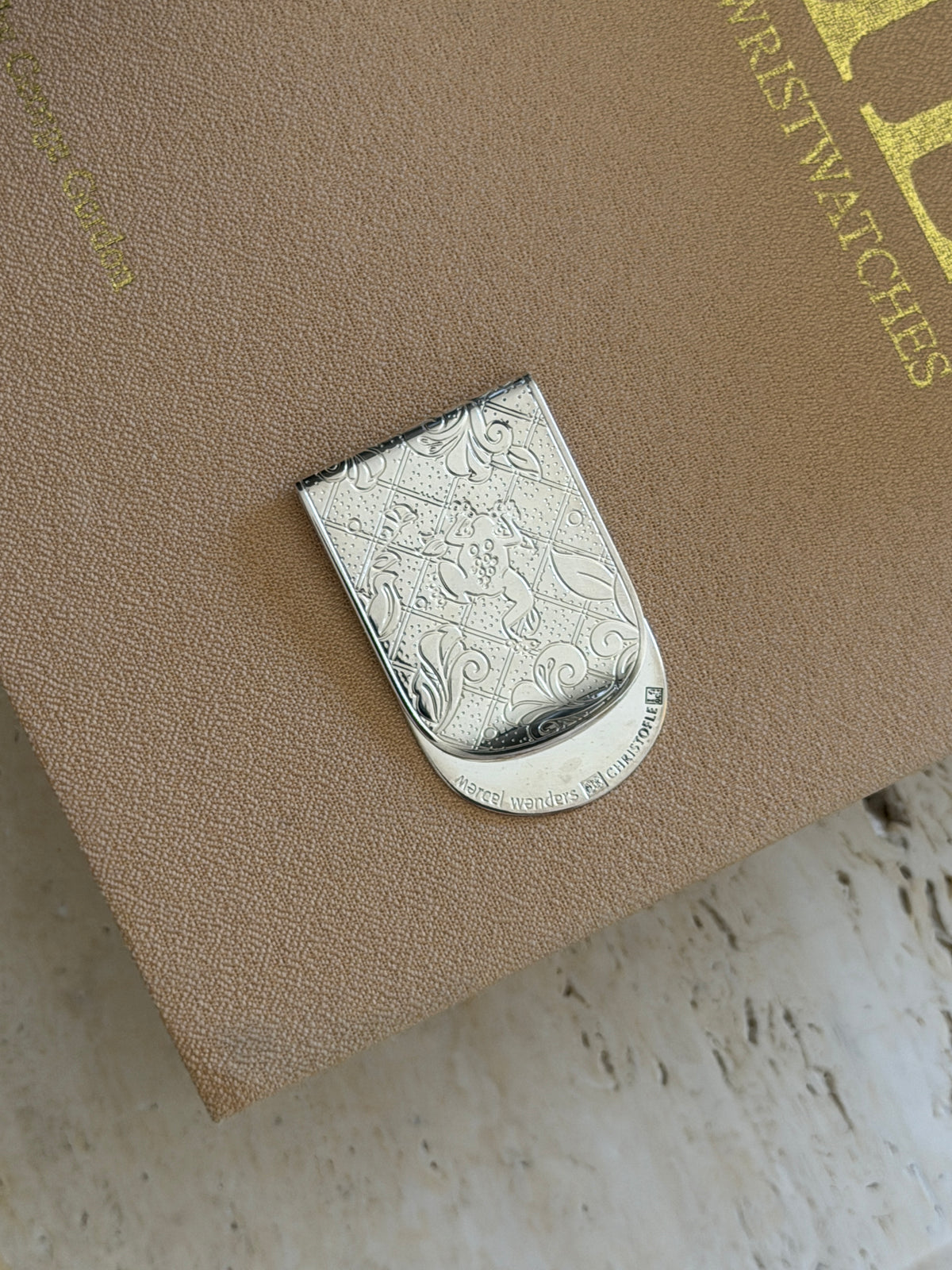 Christofle Jardin silver-plated engraved money clip by Marcel Wanders on book cover from Collectors Gene