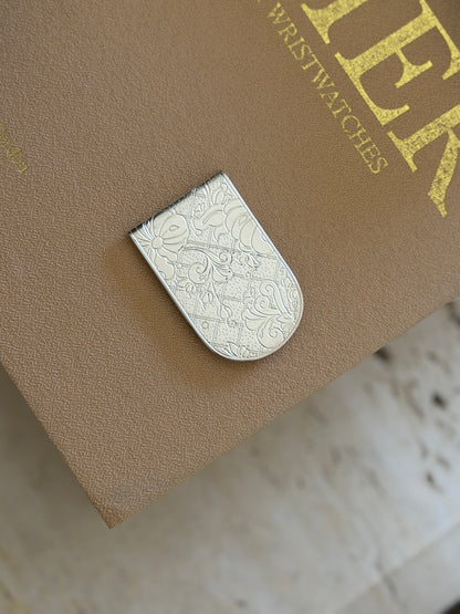 Close-up view showing intricate French garden botanical engraving on Christofle silver money clip