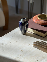 Meiji period vase in deep cobalt glaze with a woven silver neck and base, beside a red ashtray and the fingers of a brass glove form