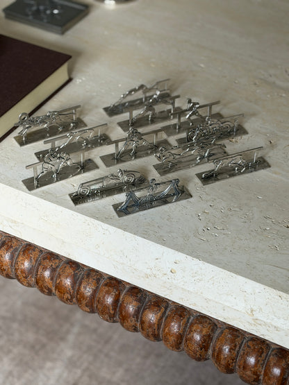 The set of twelve Art Deco knife rests on the corner of a travertine coffee table above its bobbin turned wood apron