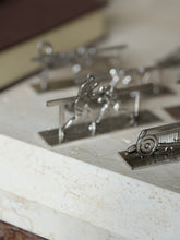 Close view of the vintage race car knife rest with round wheels and louvered hood, the boxing pair rest blurred behind