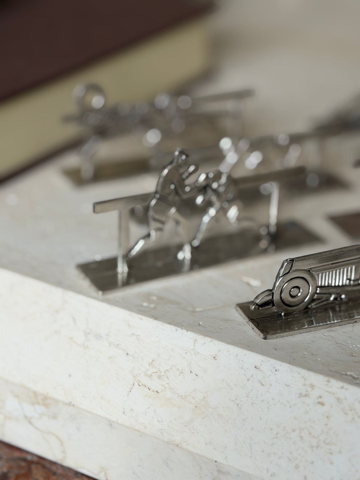 Close view of the vintage race car knife rest with round wheels and louvered hood, the boxing pair rest blurred behind
