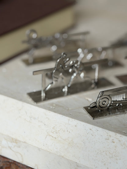 Close view of the vintage race car knife rest with round wheels and louvered hood, the boxing pair rest blurred behind