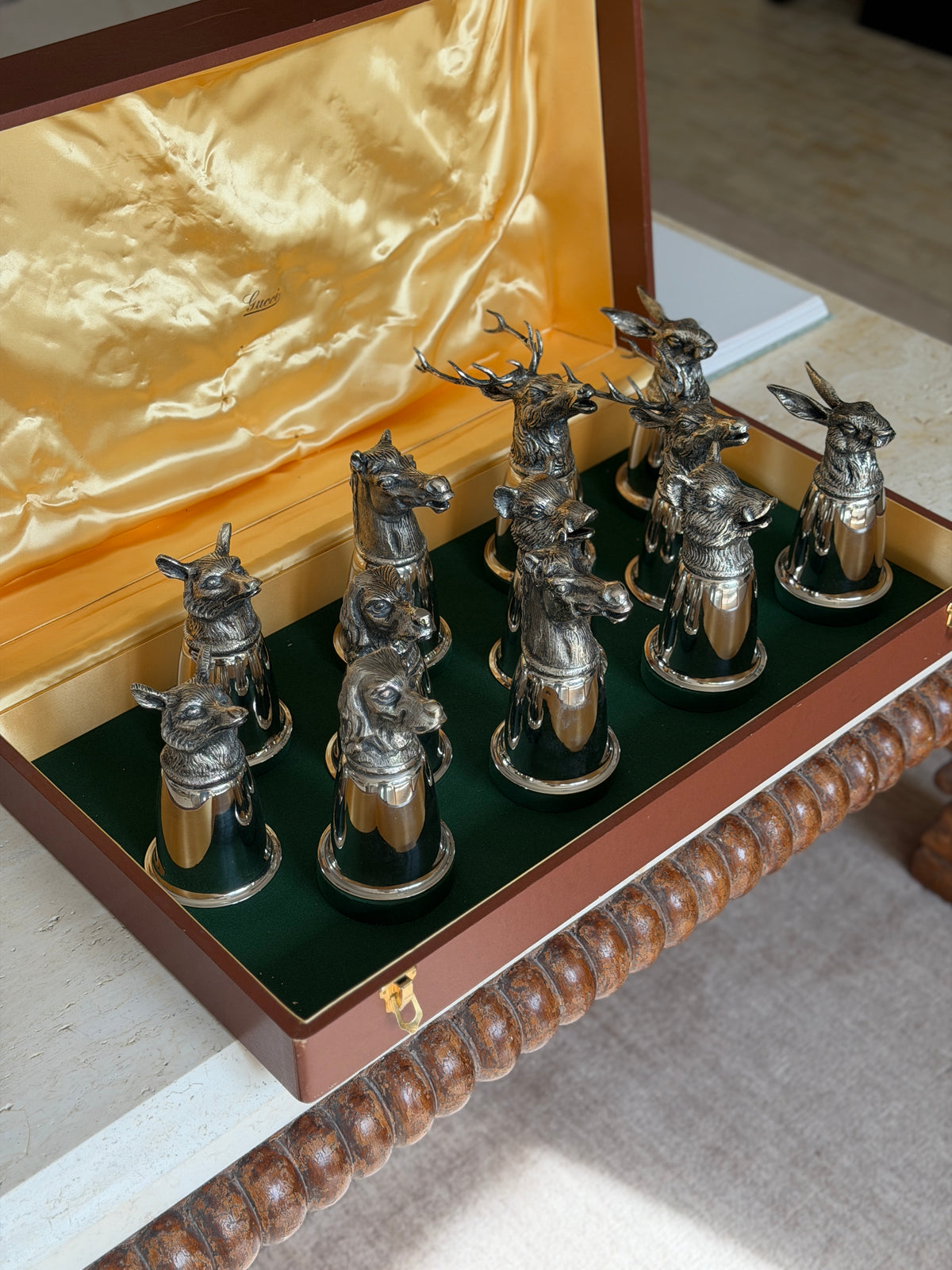 The complete set of stirrup cups viewed from a third angle, with the two large antlered stag heads prominent at the back beside a hare