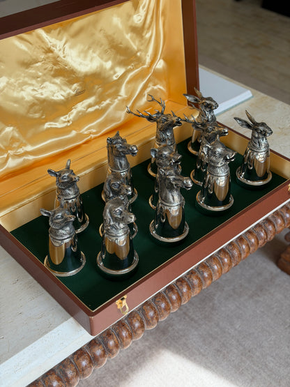 The complete set of stirrup cups viewed from a third angle, with the two large antlered stag heads prominent at the back beside a hare