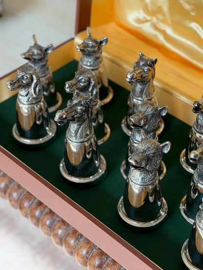 Close-up of a group of horse and boar head cups, showing the detailed modeling of the manes and bristles against the green baize lining