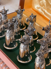 Close overhead view of several heads clustered together, including fox, horse, and boar motifs, with the Gucci name faintly stamped on one cup&
