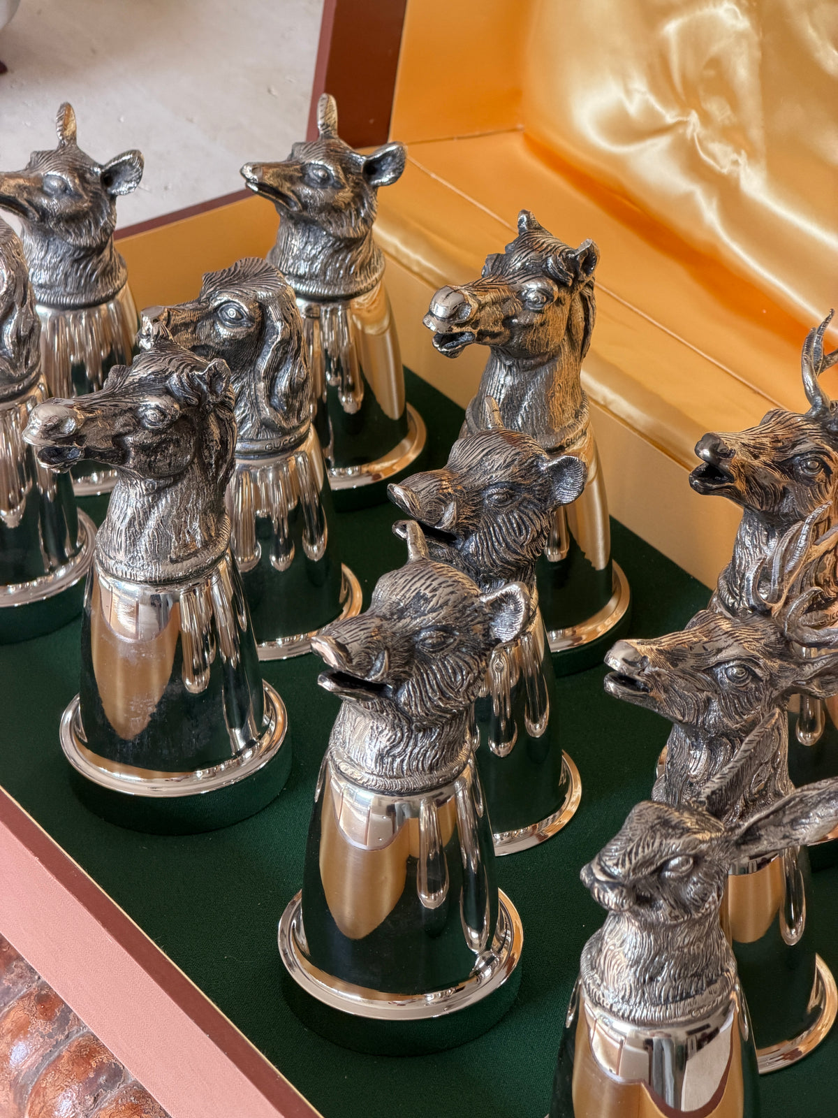 Close overhead view of several heads clustered together, including fox, horse, and boar motifs, with the Gucci name faintly stamped on one cup&