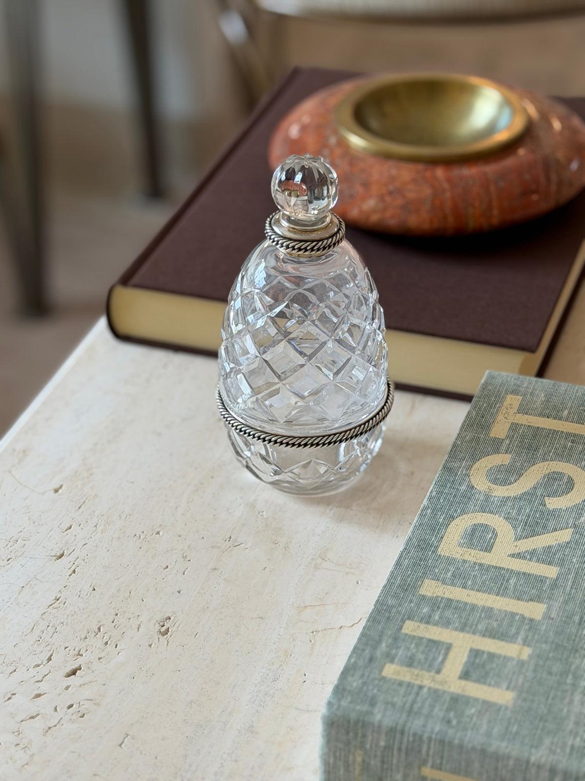 Angled view of the Hermes crystal bottle showing its faceted diamond-cut pattern