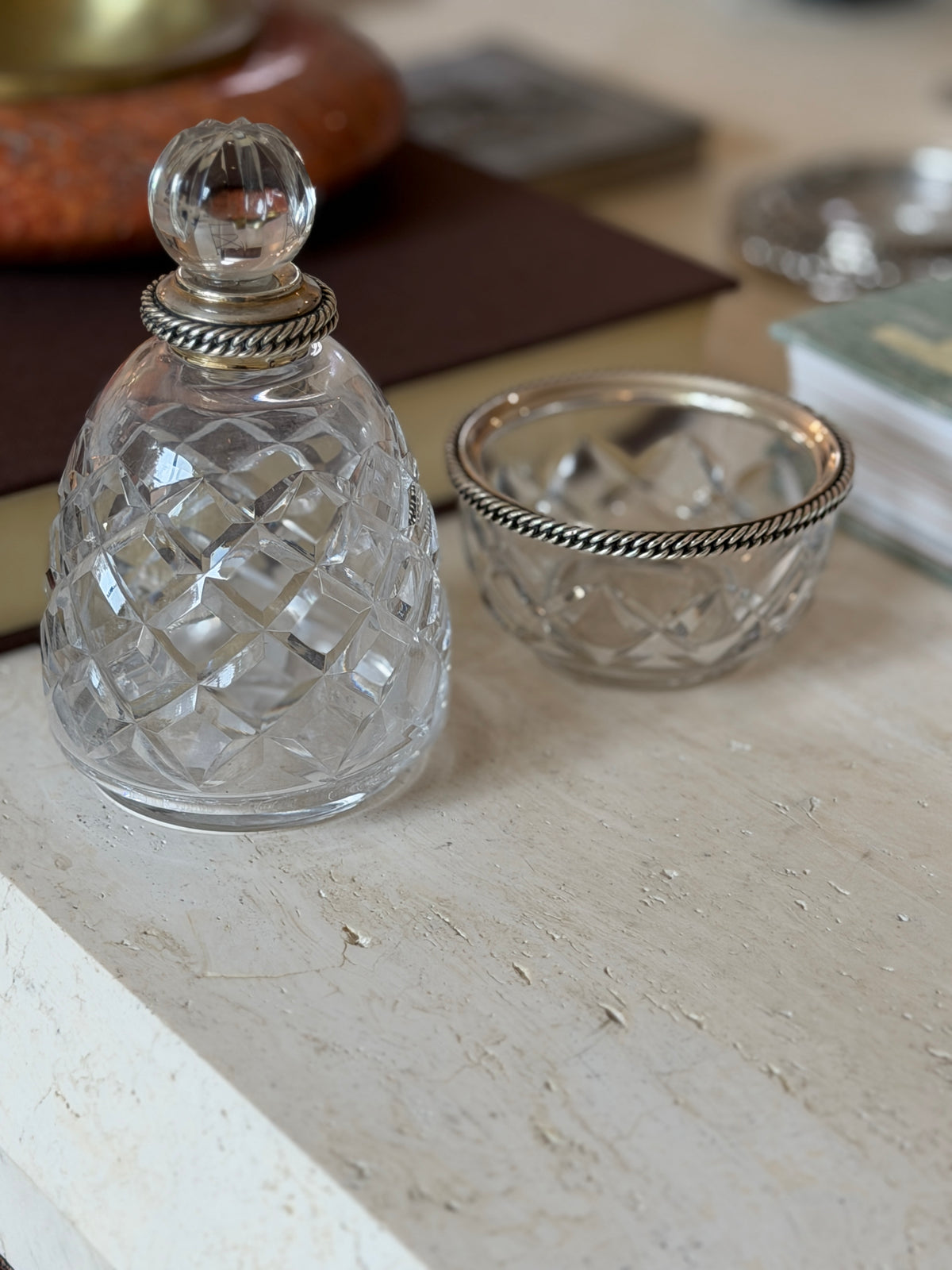 Close-up of the Hermes crystal bottle and bowl showing their matching diamond-cut pattern