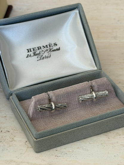 Pair of Hermes rope bar cufflinks set on the lilac velvet cushion of their original gray suede presentation box