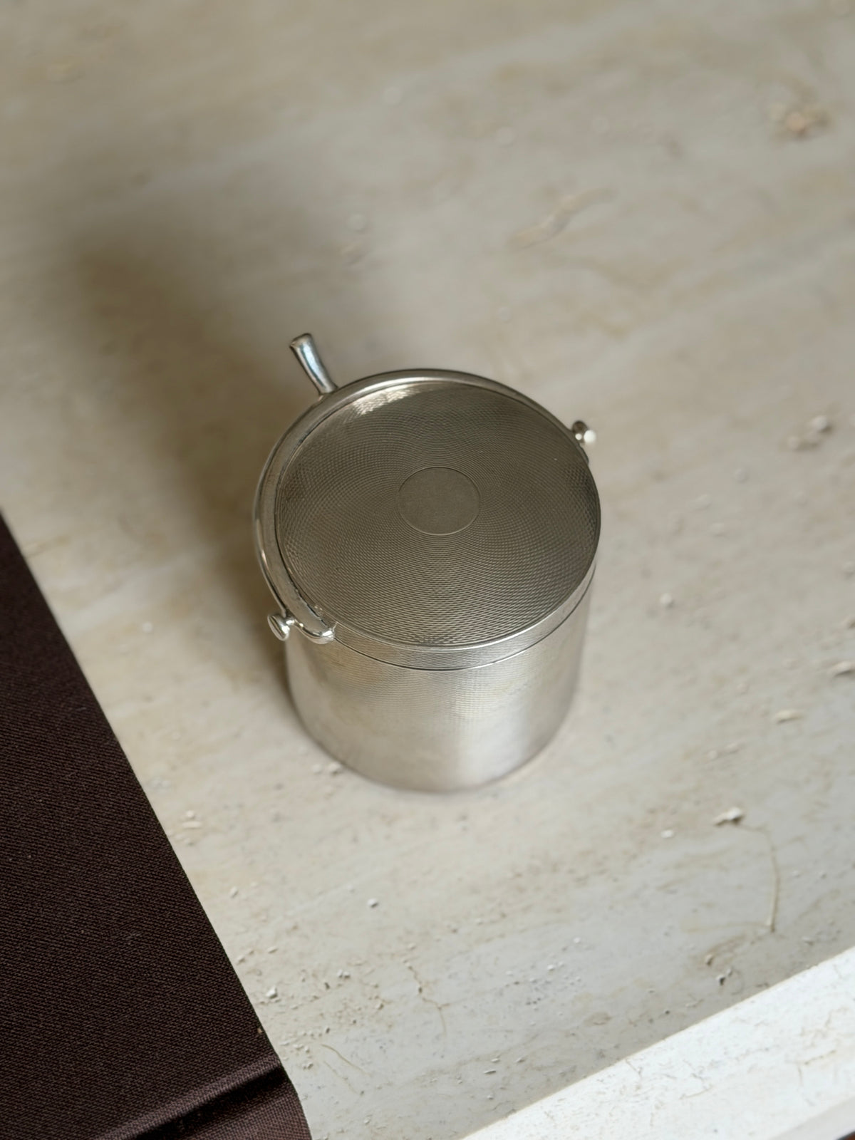 High angle view of the Hermes spur cigarette box, concentric guilloche on the lid around a plain center disc and the spur neck projecting behind