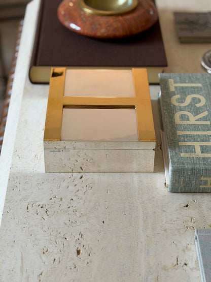 Closed Hermes humidor with brass H accents displayed among other Hermes desk pieces
