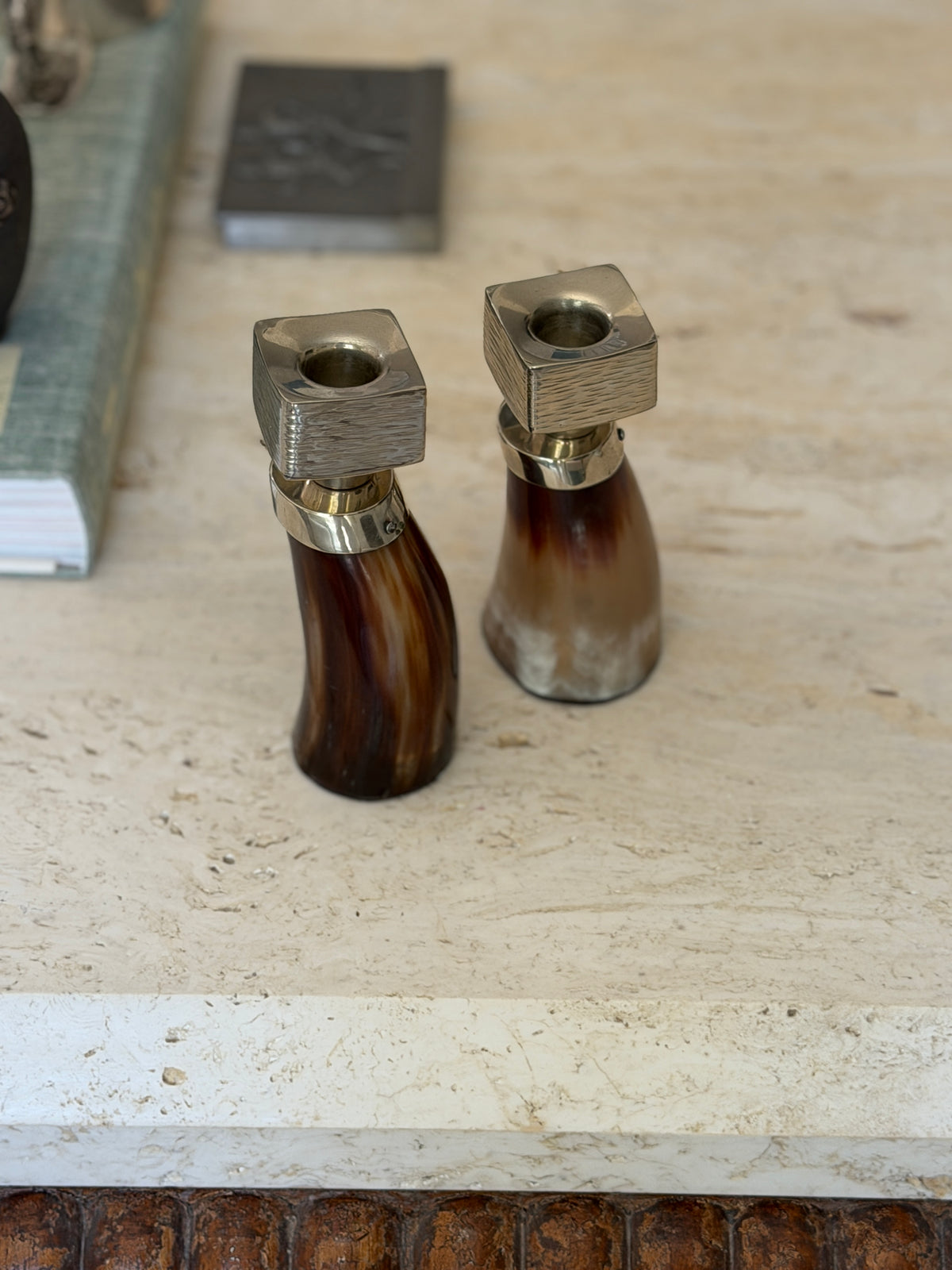 High angle view of two polished horn candle holders with geometric nickel silver tops available at Collectors Gene