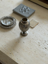 Mario Buccellati silver vase on travertine, an egg shaped body with fine textured engraving and applied floral rosettes, a chain link coaster and pewter box nearby