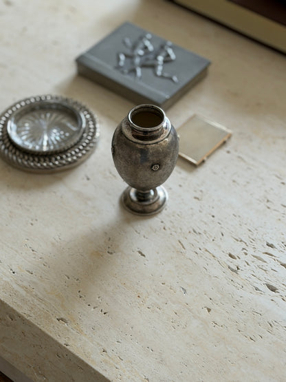Mario Buccellati silver vase on travertine, an egg shaped body with fine textured engraving and applied floral rosettes, a chain link coaster and pewter box nearby