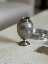 Mario Buccellati vase with rosettes and a stepped round foot on travertine, a silver cigarette case and chain coaster beside