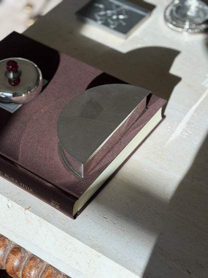 Angled view of the semicircular Olivetti box on the Superfine Tailoring Black Style book, the fan of engine turned panels catching sunlight
