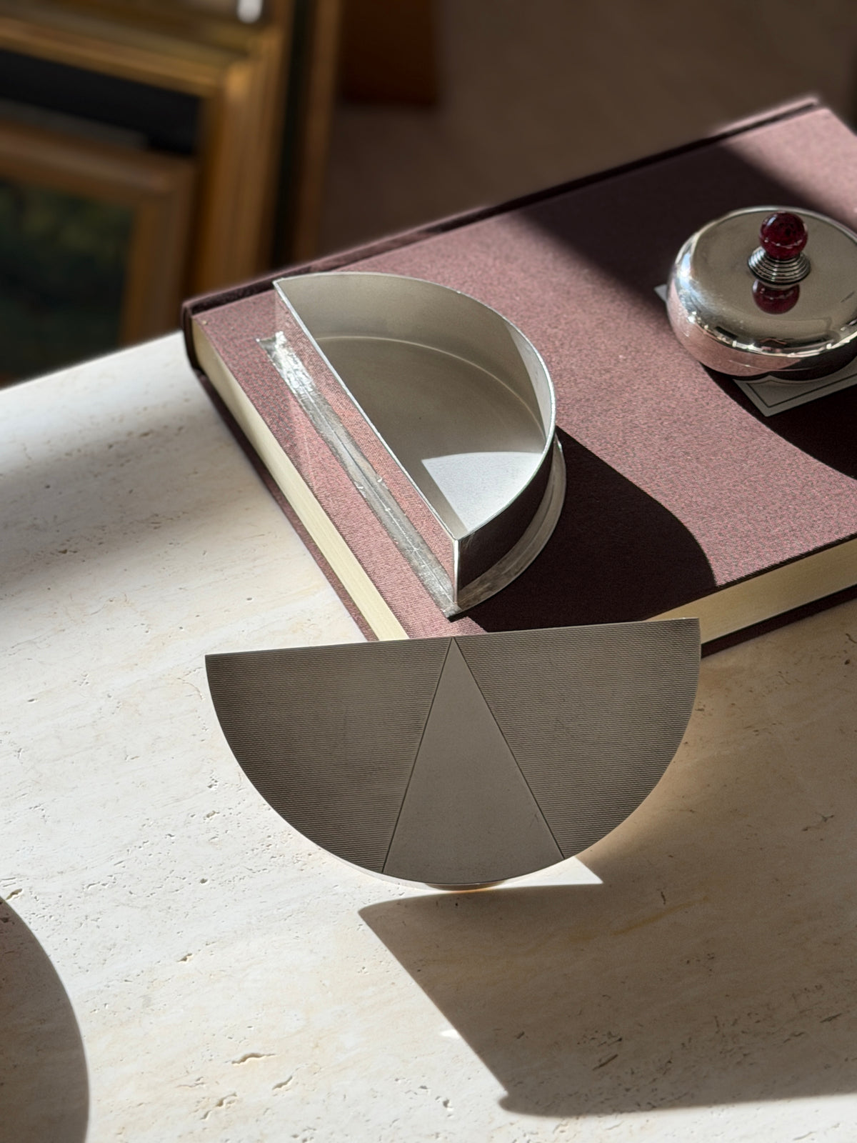 Olivetti box with the lid set aside, revealing a plain polished silver plated interior, the three part engine turned lid in front