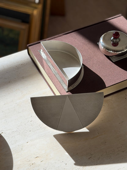 Olivetti box with the lid set aside, revealing a plain polished silver plated interior, the three part engine turned lid in front