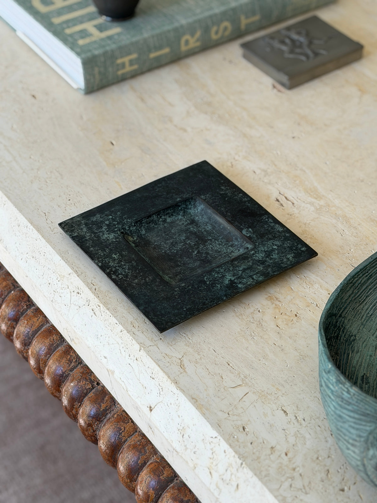Angled desk context view of minimalist patinated bronze square catchall tray on light stone surface
