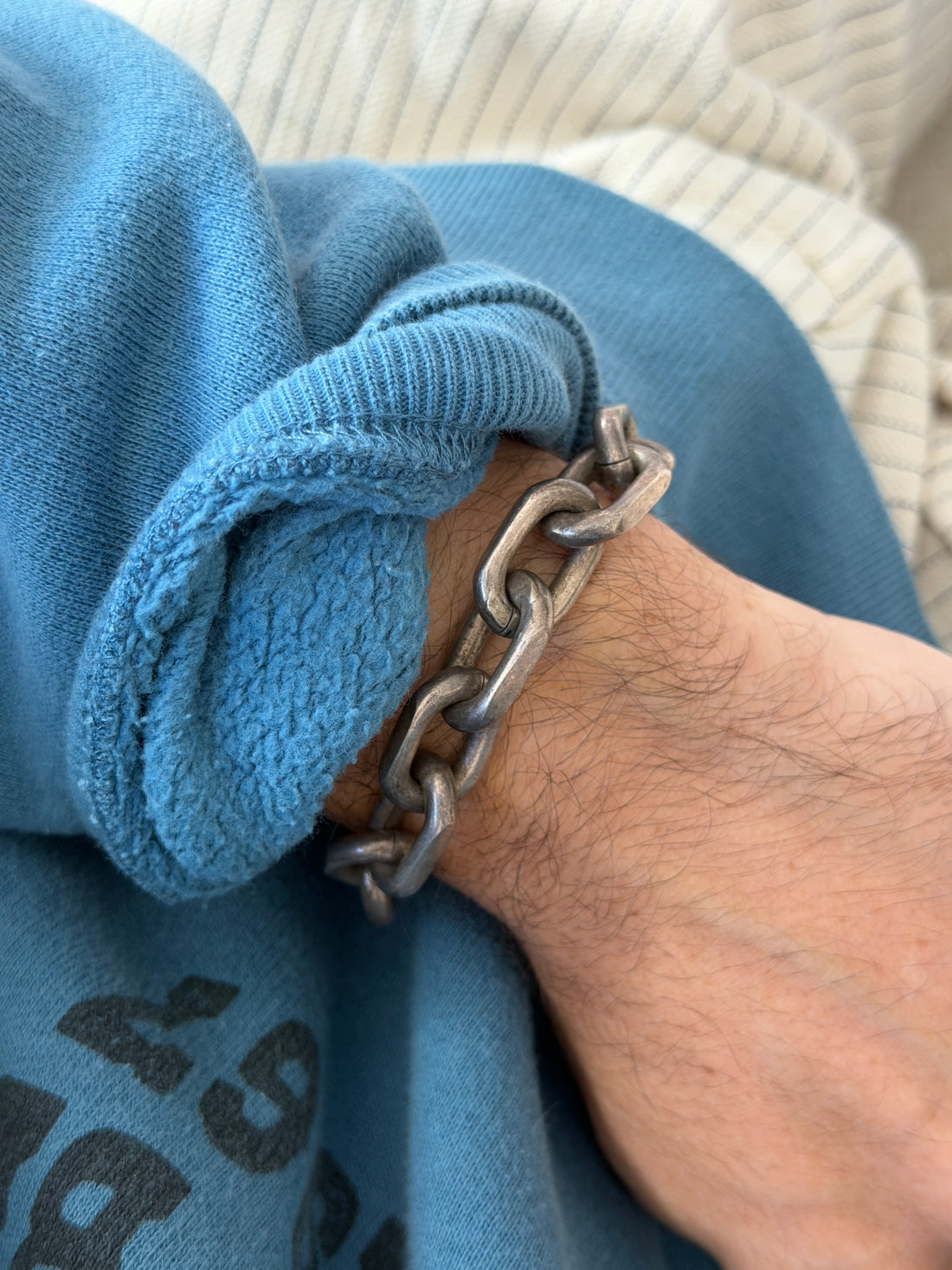 Bracelet worn on the wrist against a printed sweatshirt