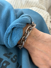 Bracelet worn on the wrist against a printed sweatshirt
