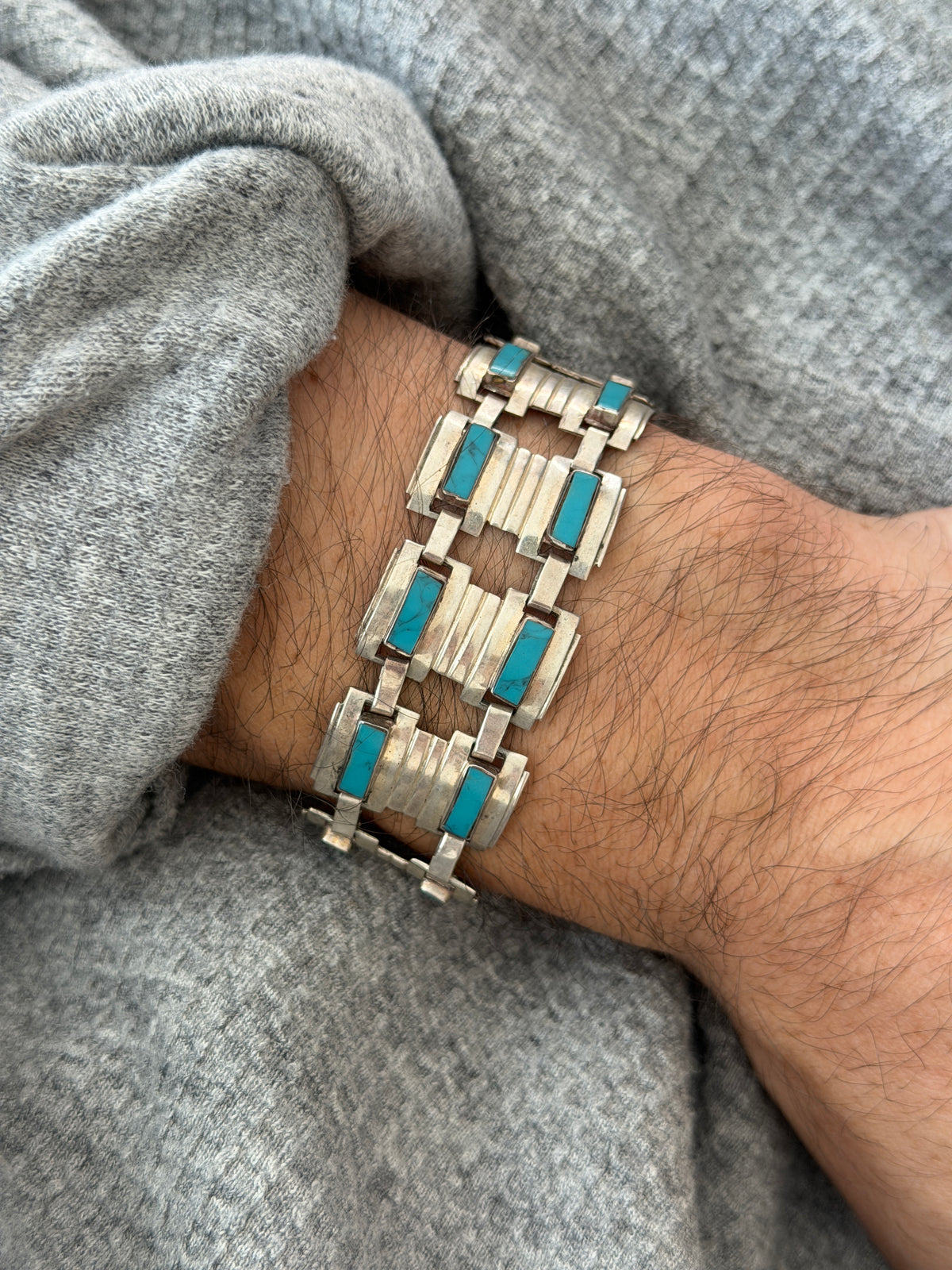 Close wrist view of the Taxco panel bracelet, paired bezel set turquoise bars on ribbed Art Deco style silver links