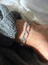 Vintage sterling silver bracelet of open rectangular panel links engraved with diagonal rope lines, joined by smooth barrel hinges, worn on the wrist