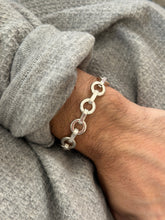 Angled wrist view of the round link bracelet, bright washer shaped rings alternating with smooth rectangular bars
