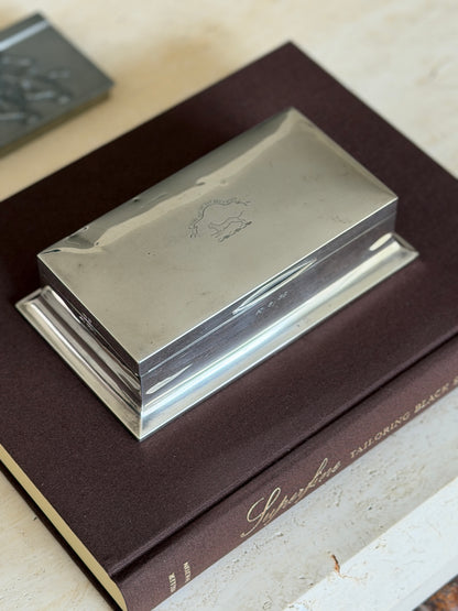 Walker and Hall sterling silver box on the Superfine Tailoring Black Style book, the lid engraved with a cat crest and motto ribbon