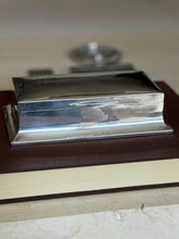 Eye level side view of the sterling box showing the flared stepped base, slim thumb lip, and engraved date 15/9/55