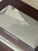 Close up of the engraved crest reading Touch Not The Cat Bot A Glove above a cat on a wreath