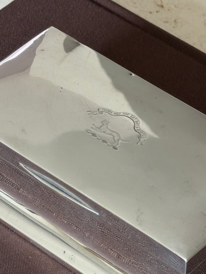 Close up of the engraved crest reading Touch Not The Cat Bot A Glove above a cat on a wreath